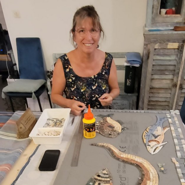 Muriel Dintheer, mosaïste, travaillant sur une mosaïque de poissons dans son atelier
