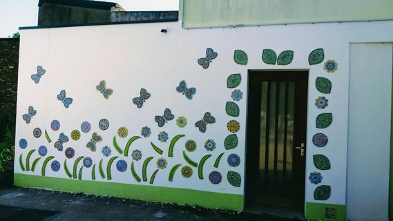 Fresque murale en mosaïque réalisée avec les jeunes de l'association UCCLA : papillons et fleurs colorées